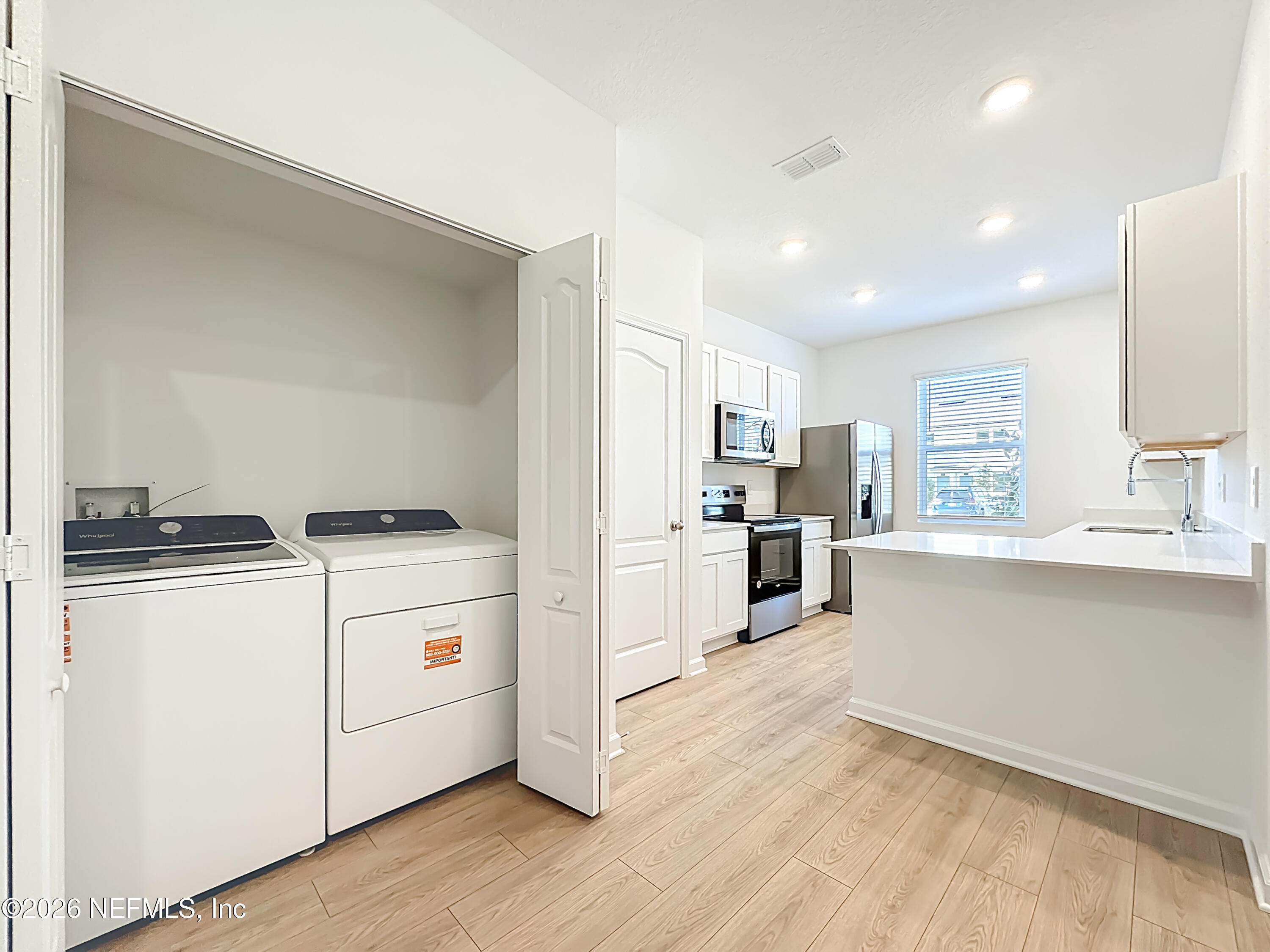 177 Palmetto Rdg Road St. Augustine, FL 32095 - Photo 4 of 19 a kitchen with cabinets wooden floor and stainless steel appliances