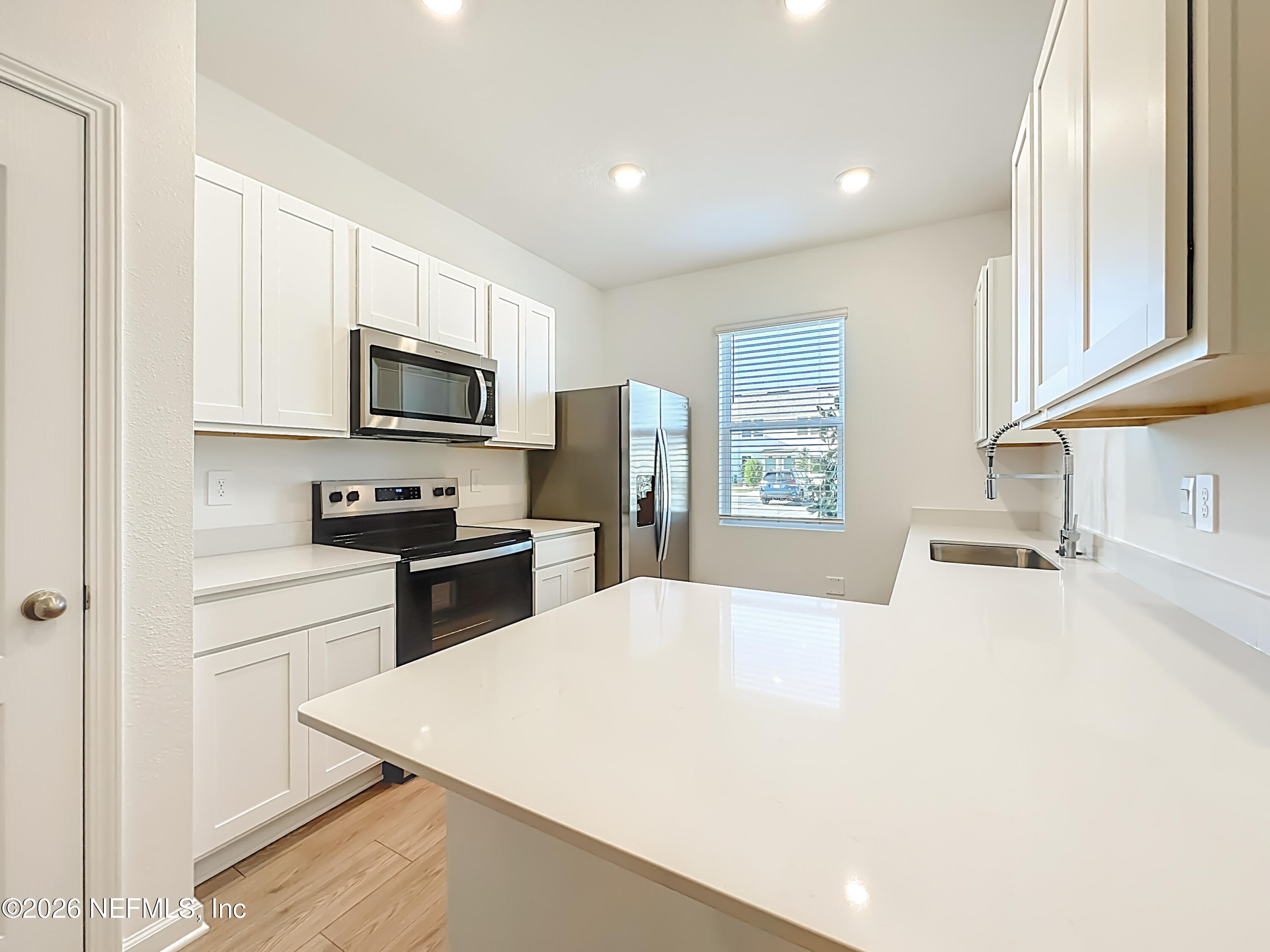 177 Palmetto Rdg Road St. Augustine, FL 32095 - Photo 7 of 19 a kitchen with a refrigerator a stove a microwave a sink and dishwasher with wooden floor