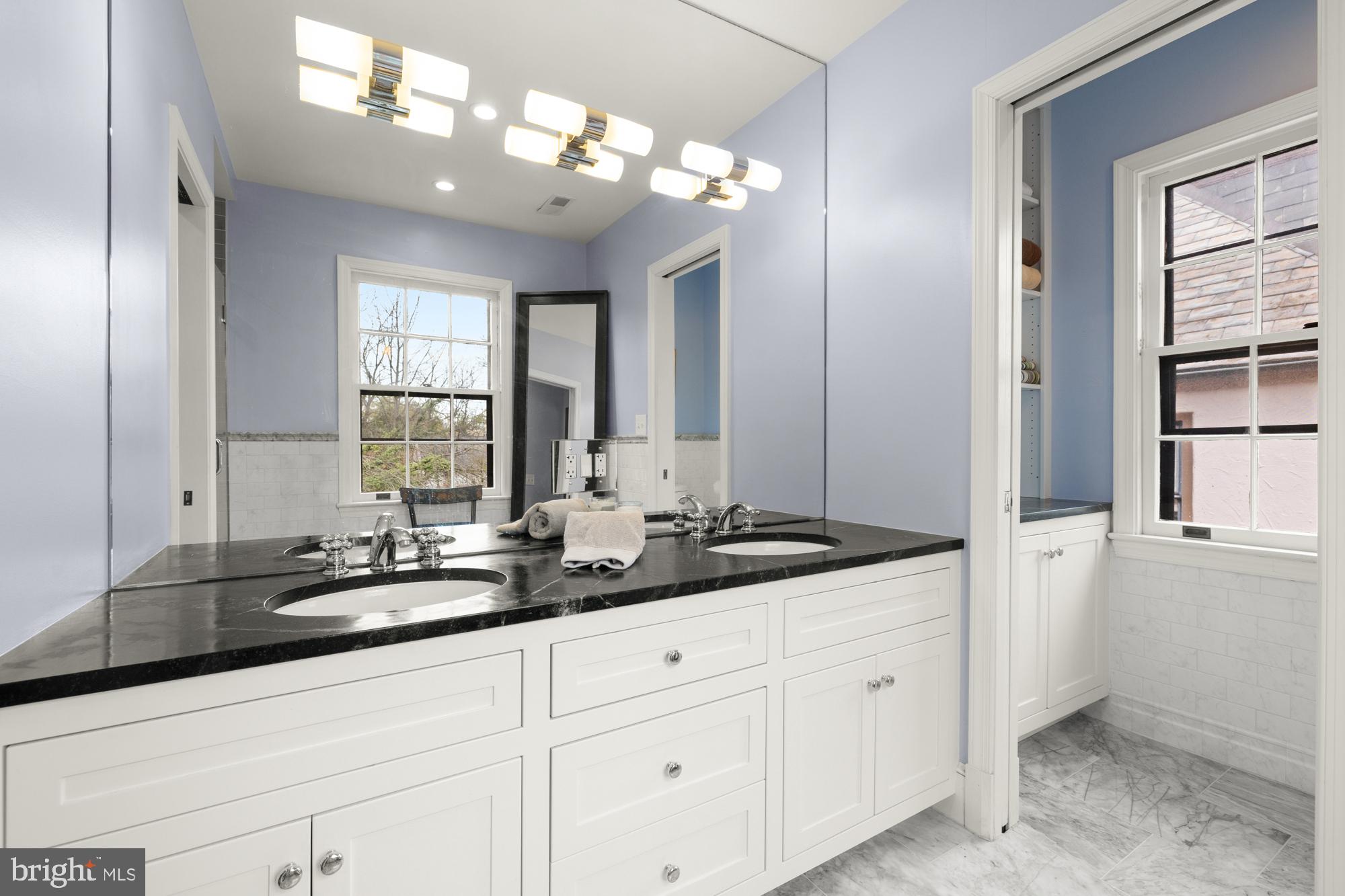 1441 Manchester Lane Northwest Washington, DC 20011 - Photo 37 of 63 a bathroom with double vanity sinks a vanity a lamp and a window