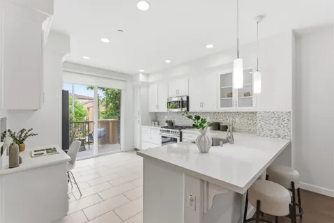 a kitchen with stainless steel appliances a sink window and cabinets