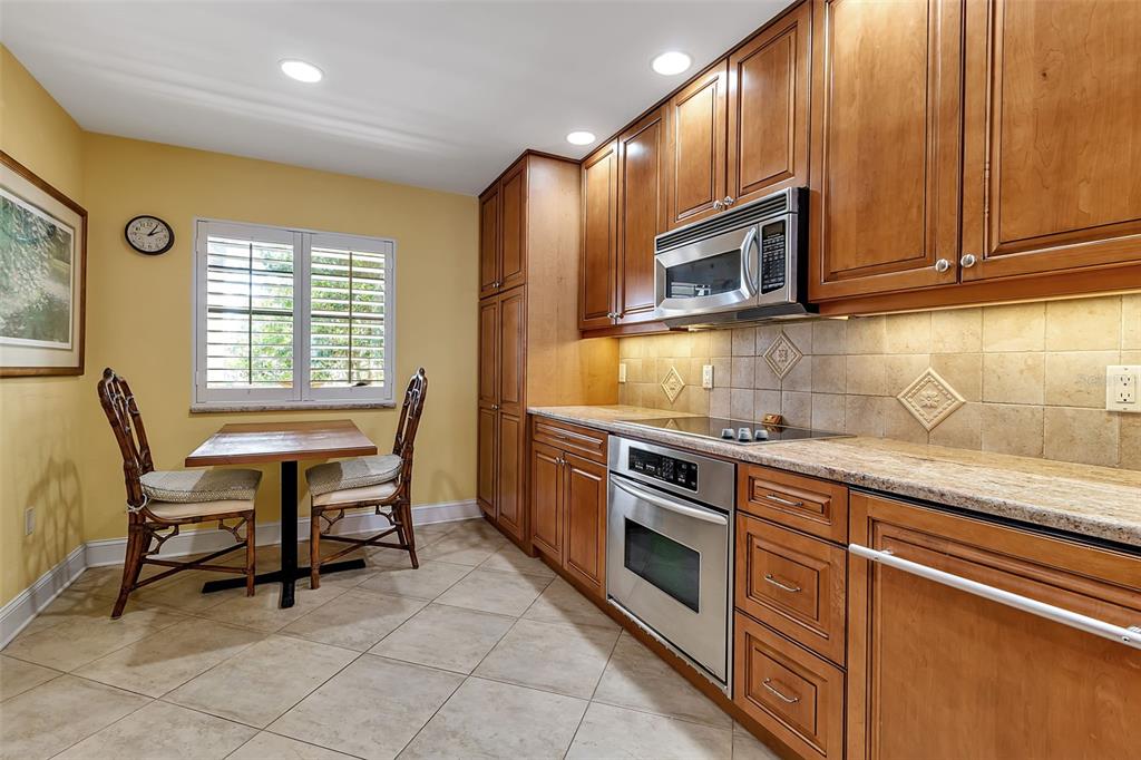 3840 Mariners Way, Unit 514A Cortez, FL 34215 - Photo 12 of 33 a kitchen with stainless steel appliances granite countertop wooden cabinets a stove top oven a sink and dishwasher