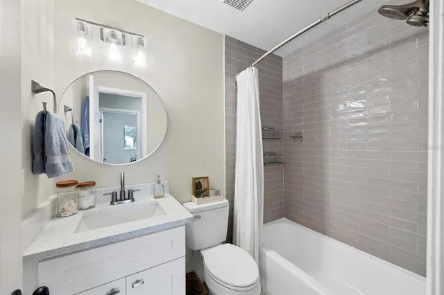 a bathroom with a toilet sink vanity tub and mirror