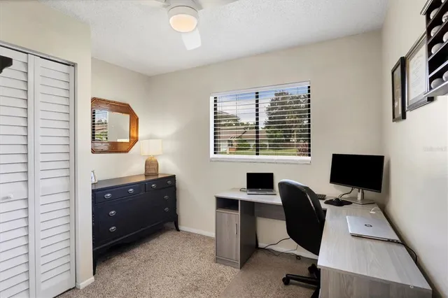 a view of a workspace with furniture and a window