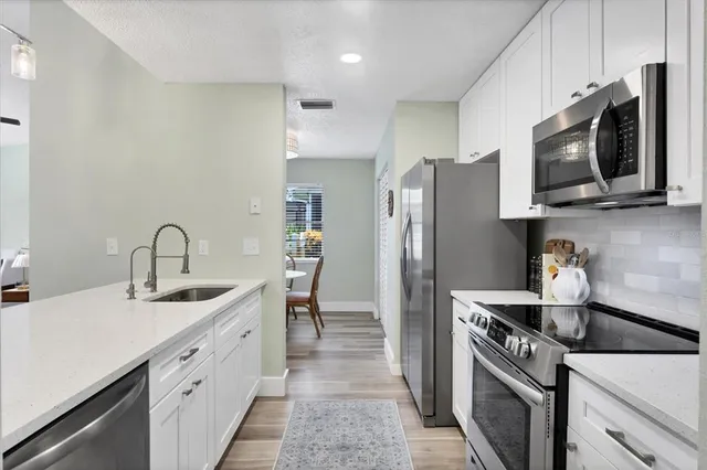 a kitchen with stainless steel appliances granite countertop a sink stove and refrigerator