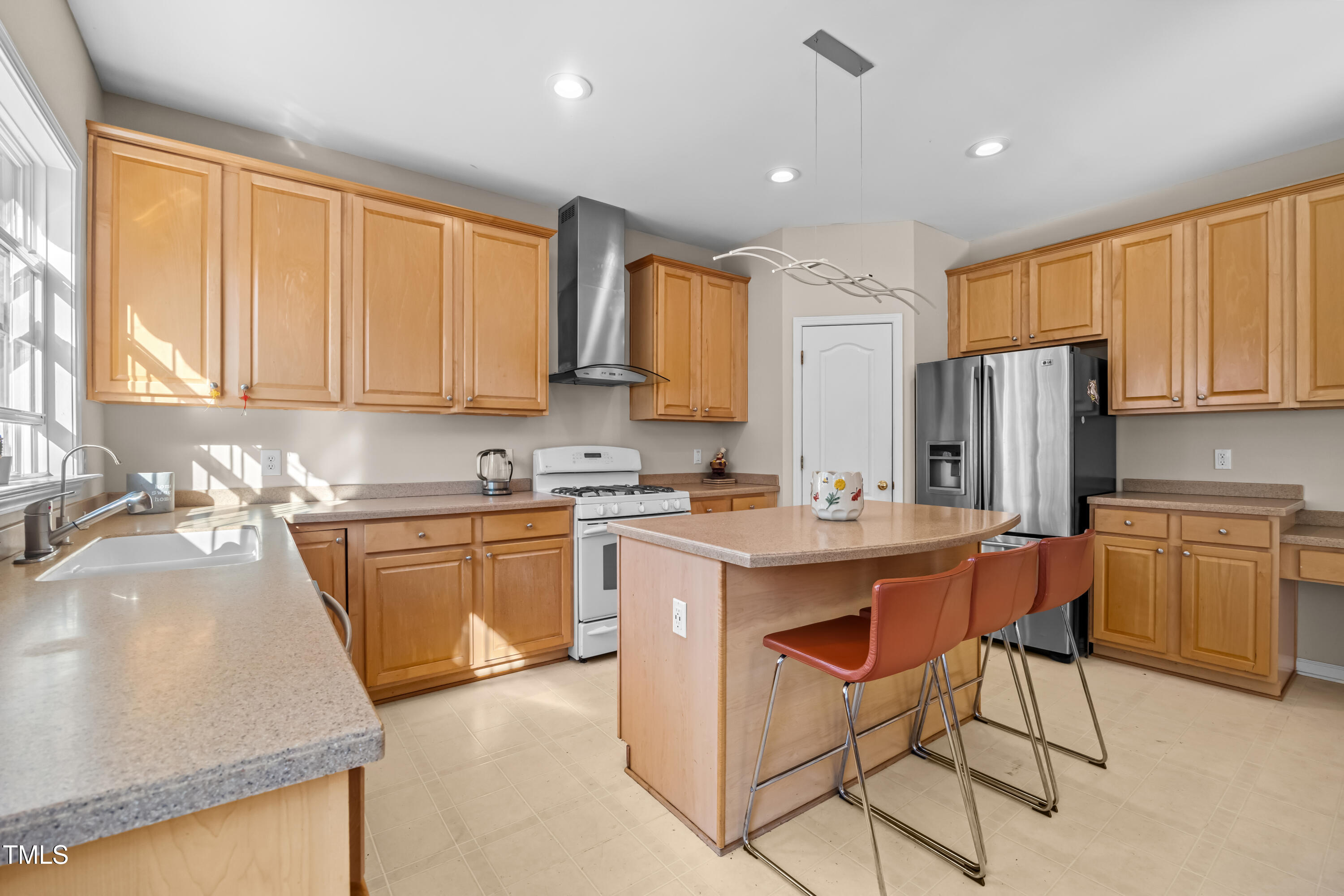 7772 Silver View Lane Raleigh, NC 27613 - Photo 12 of 55 a kitchen with stainless steel appliances granite countertop a sink a stove a refrigerator cabinets and chairs