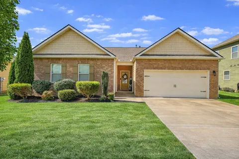 a view of a house with a yard and garage
