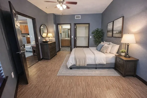 a bedroom with a large bed and a mirror on dresser