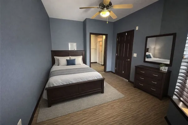 a bedroom with a bed and a flat tv screen on dresser