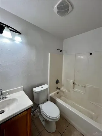 a bathroom with a granite countertop toilet sink and mirror