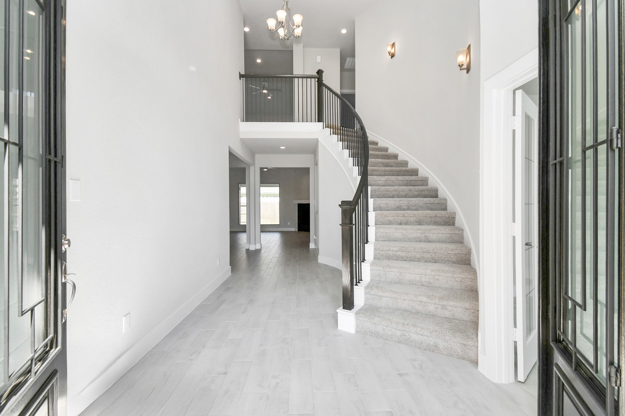 3106 Native Spg Drive Spring, TX 77373 - Photo 5 of 38 As you step into the threshold of this luxurious home, you'll soon be welcomed by an elegant glass door. Inside, soaring ceilings amplify the spaciousness, while the refined wood-look tile flooring and oversized baseboards exude sophistication and charm. Sample photo of completed home with similar floor plan. Actual colors and selections may vary.