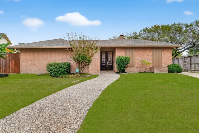 a front view of a house with a garden and plants