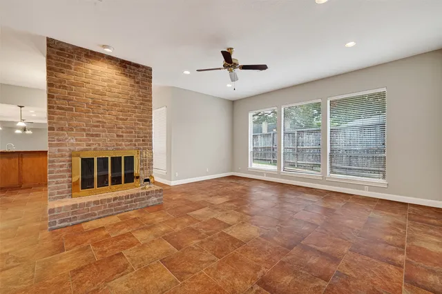 a view of an empty room with a fireplace and a window