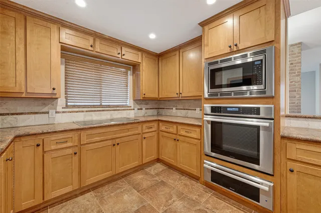 a view of an empty room with a ceiling fan and window