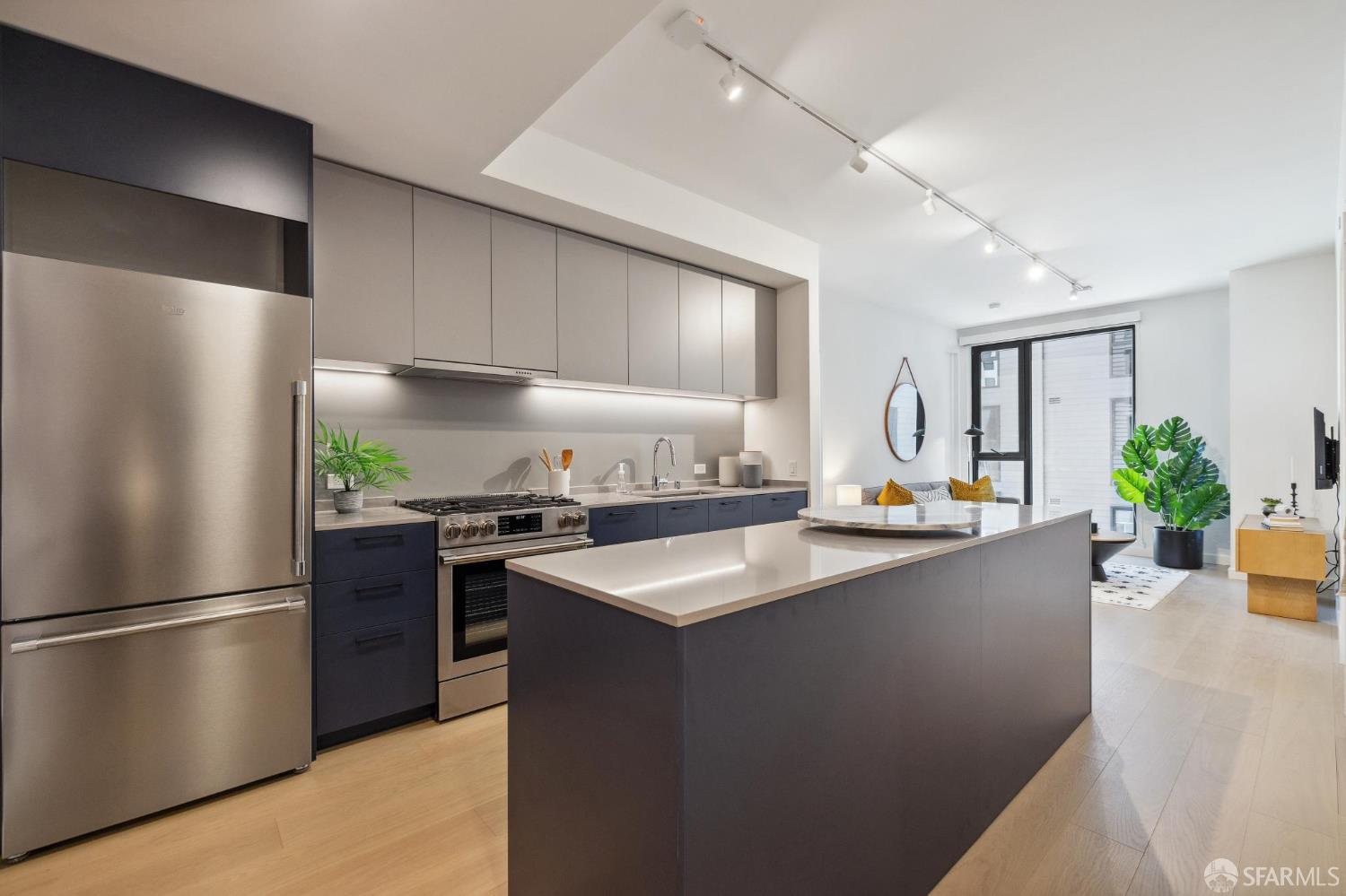 988 Harrison Street, Unit YH2 San Francisco, CA 94107 - Photo 6 of 17 a kitchen with stainless steel appliances a refrigerator a sink a stove a dining table and chairs