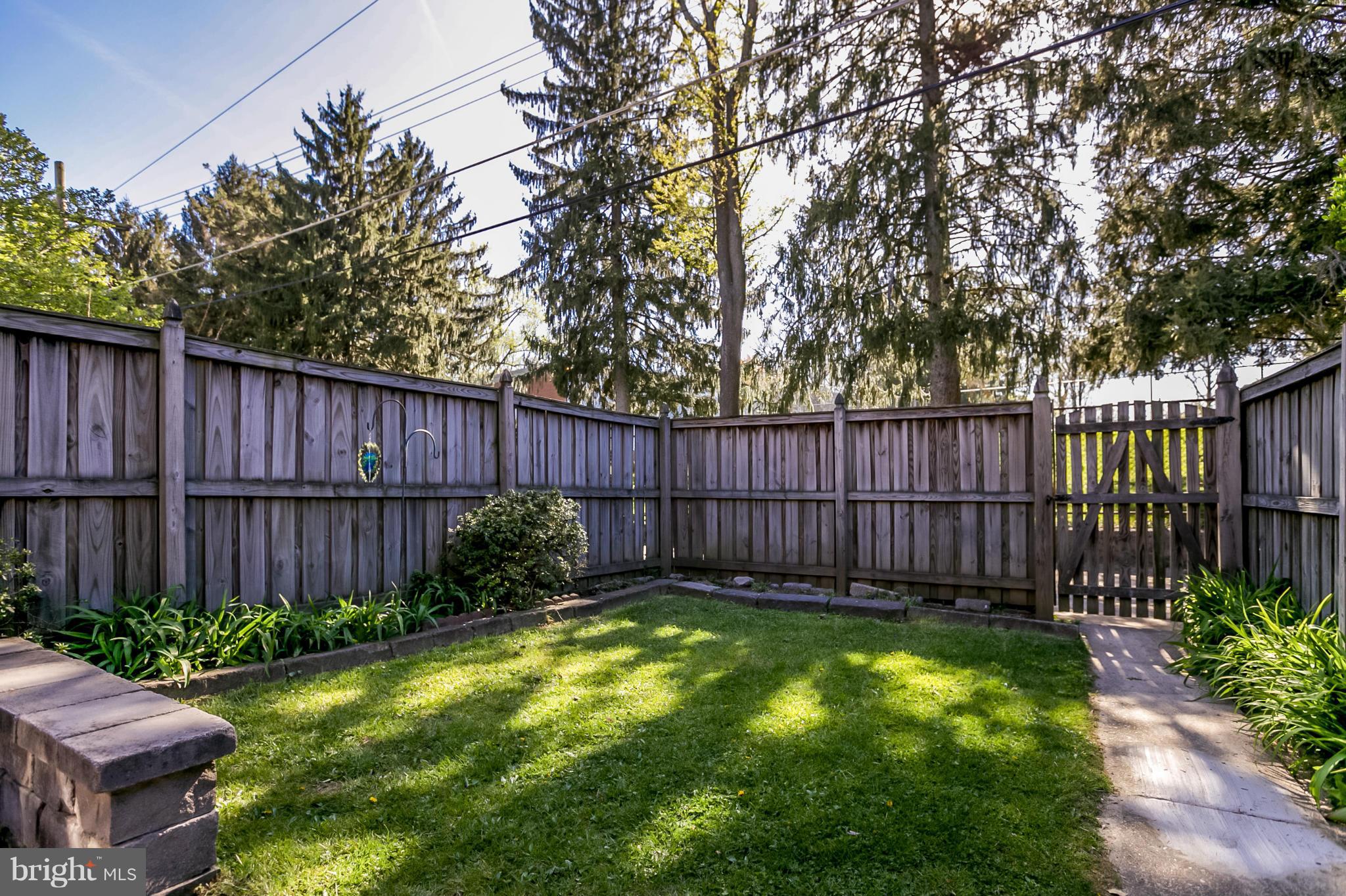 7120 Heathfield Road Baltimore, MD 21212 - Photo 28 of 29 a view of a backyard with a large tree and wooden fence