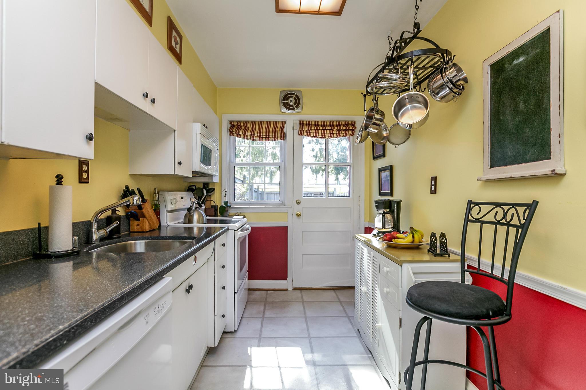 7120 Heathfield Road Baltimore, MD 21212 - Photo 10 of 29 a kitchen with a sink a stove and chairs