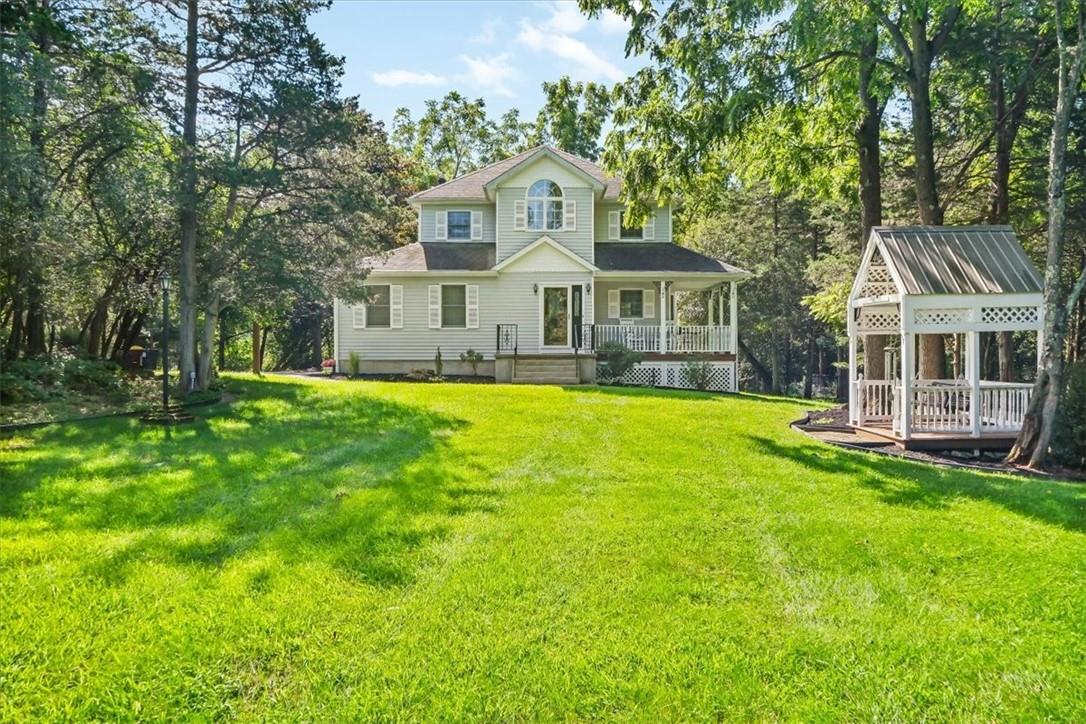 a front view of a house with a yard and trees