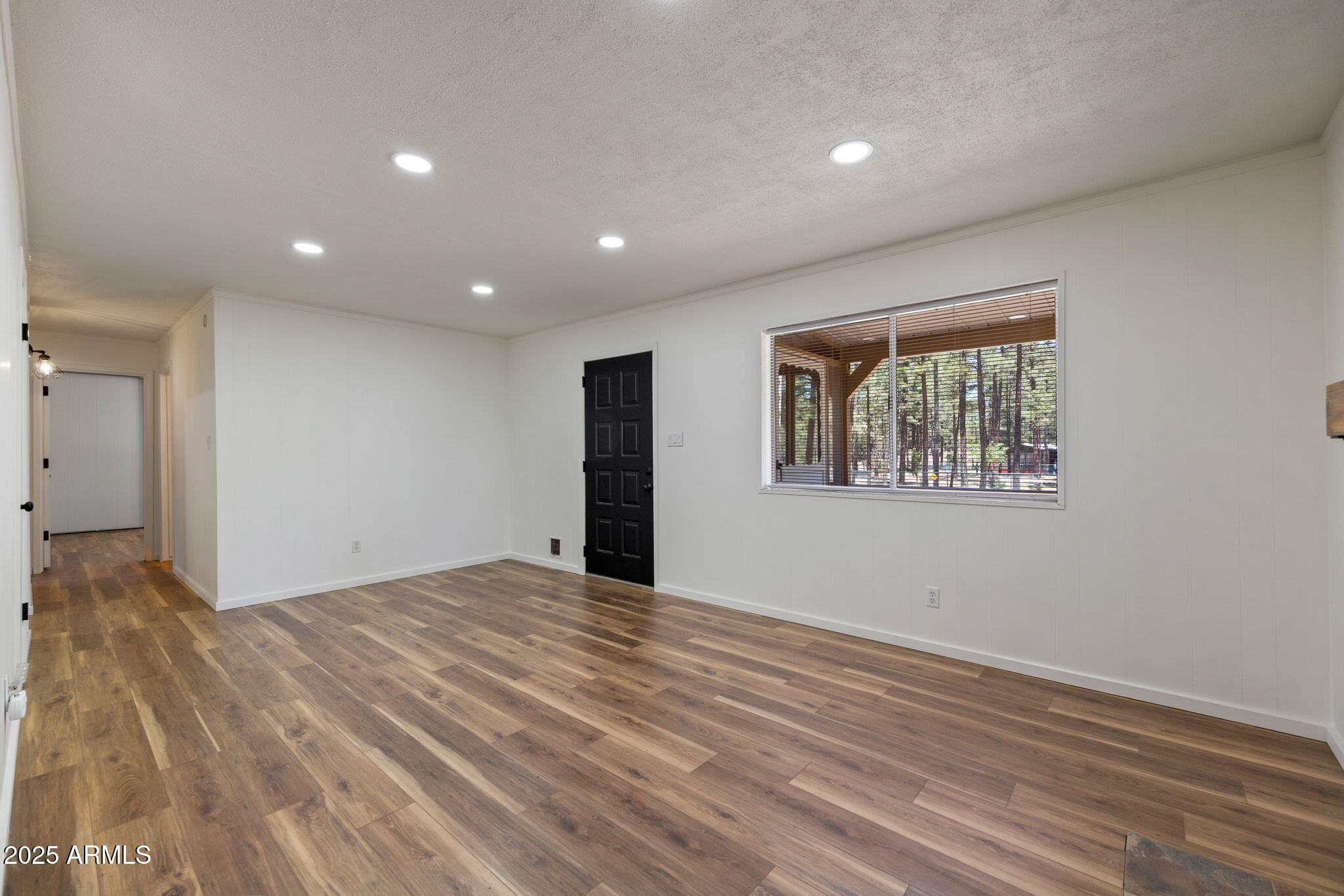 2127 Pony Road Overgaard, AZ 85933 - Photo 12 of 30 a view of an empty room with wooden floor and a window