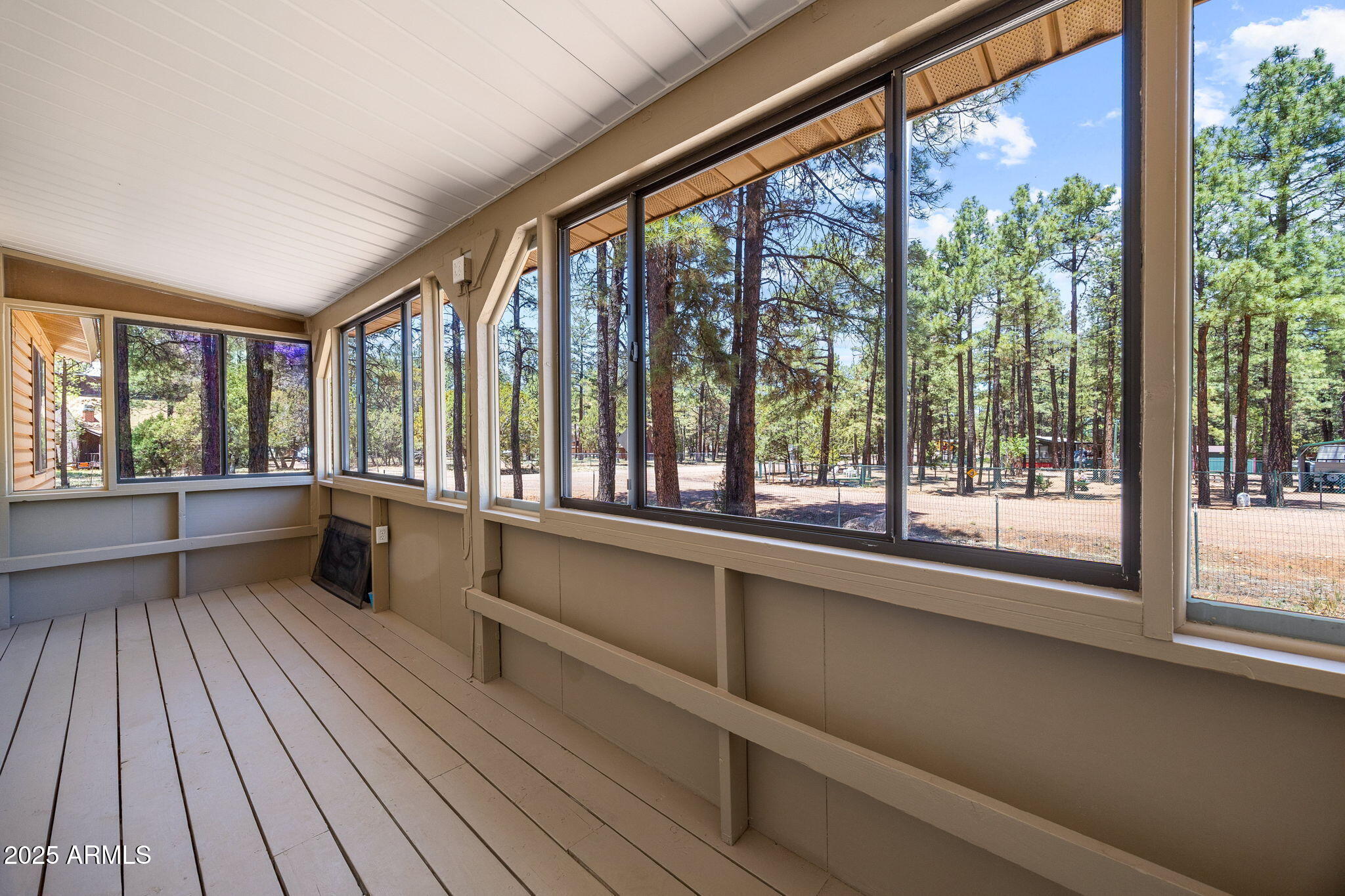 2127 Pony Road Overgaard, AZ 85933 - Photo 21 of 30 a view of an empty room with wooden floor and a window