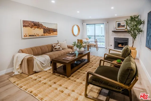 a living room with furniture a fireplace and a large mirror