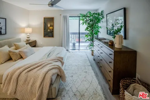 a spacious bedroom with a bed and a potted plant