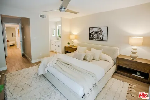 a spacious bedroom with a bed and a lamp