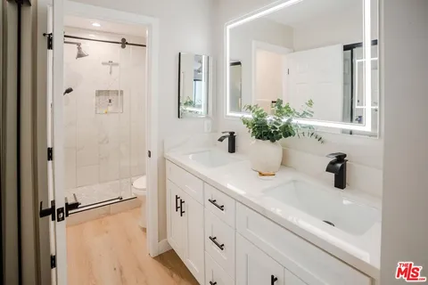 a bathroom with a shower sink vanity and mirror