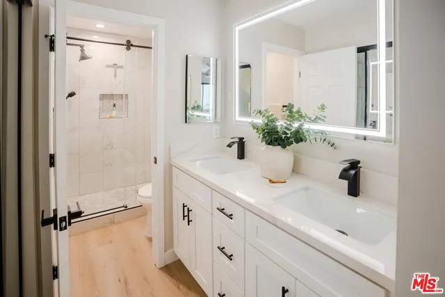a bathroom with a shower sink vanity and mirror