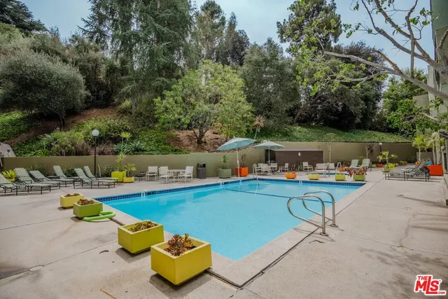 a view of a swimming pool with a lounge chair and a fire pit