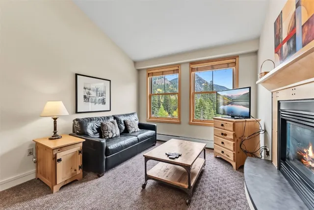 a living room with furniture a large window and a fireplace