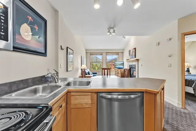 a kitchen with stainless steel appliances granite countertop a sink a stove and a wooden floors