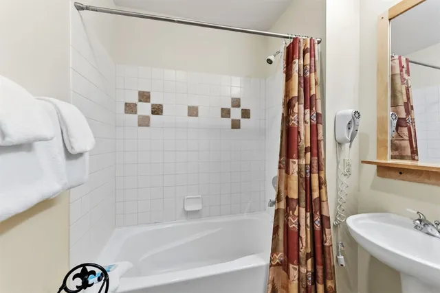 a bathroom with a shower curtain and a sink