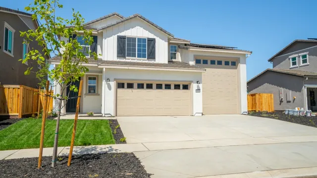 a view of a white house with a yard and plants