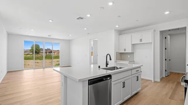 a kitchen with granite countertop a sink and a refrigerator