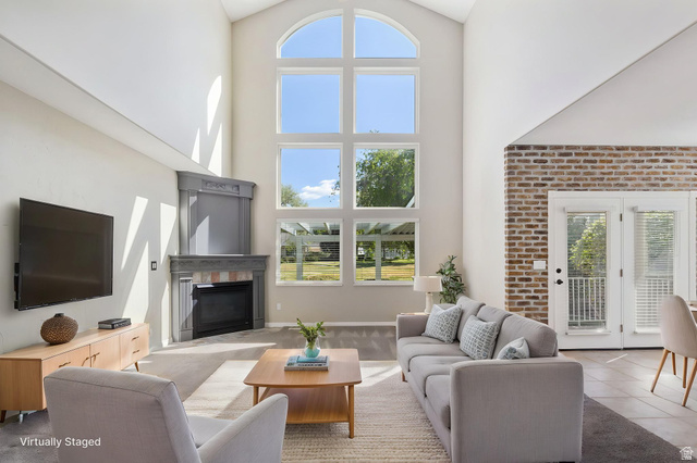1417 Blacksmith Lane Draper, UT 84020 - Photo 11 of 57 Vaulted ceiling living space featuring a corner fireplace with stone surround, a large arched window array, and French doors