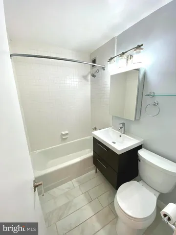 a bathroom with a sink mirror vanity and toilet