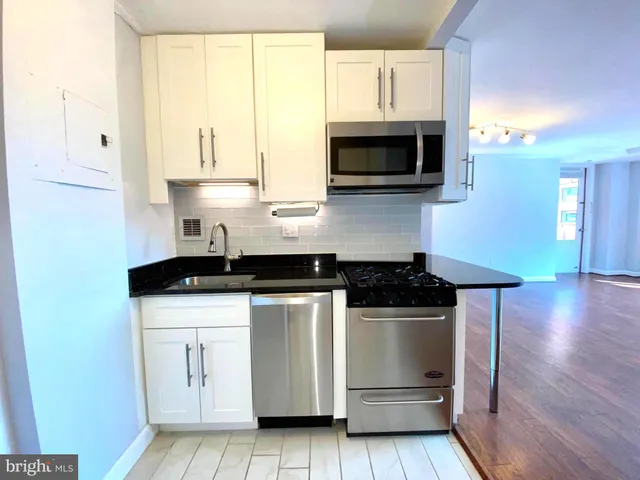 a kitchen with stainless steel appliances a stove a microwave and cabinets