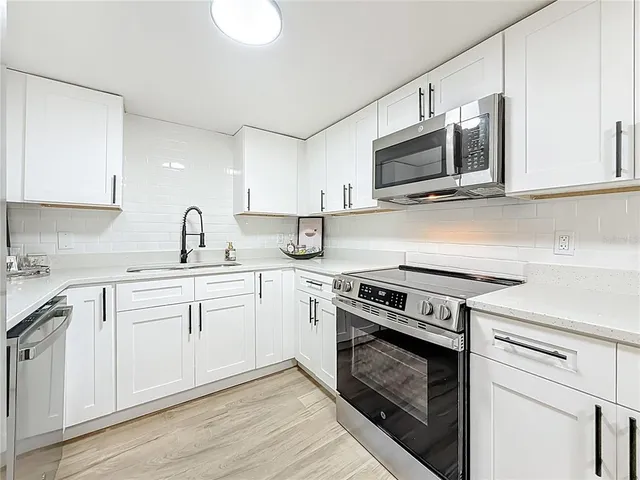 a kitchen with white cabinets and white appliances
