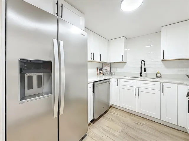a kitchen with stainless steel appliances white cabinets and stove top oven