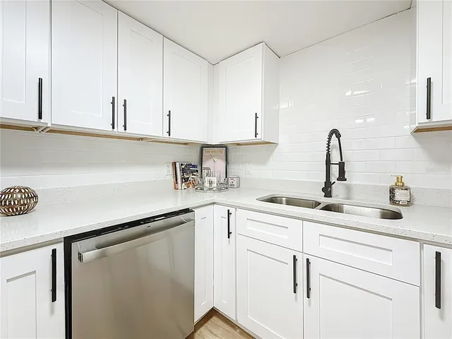 a kitchen with white cabinets and white appliances