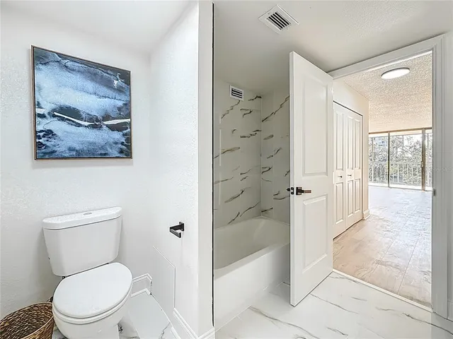 an empty room with wooden floor and mirror