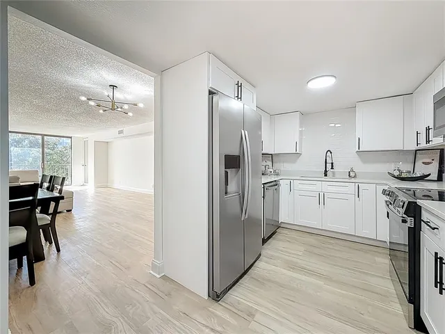 a kitchen with white cabinets and stainless steel appliances