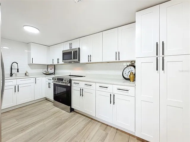 a kitchen with cabinets appliances and a sink