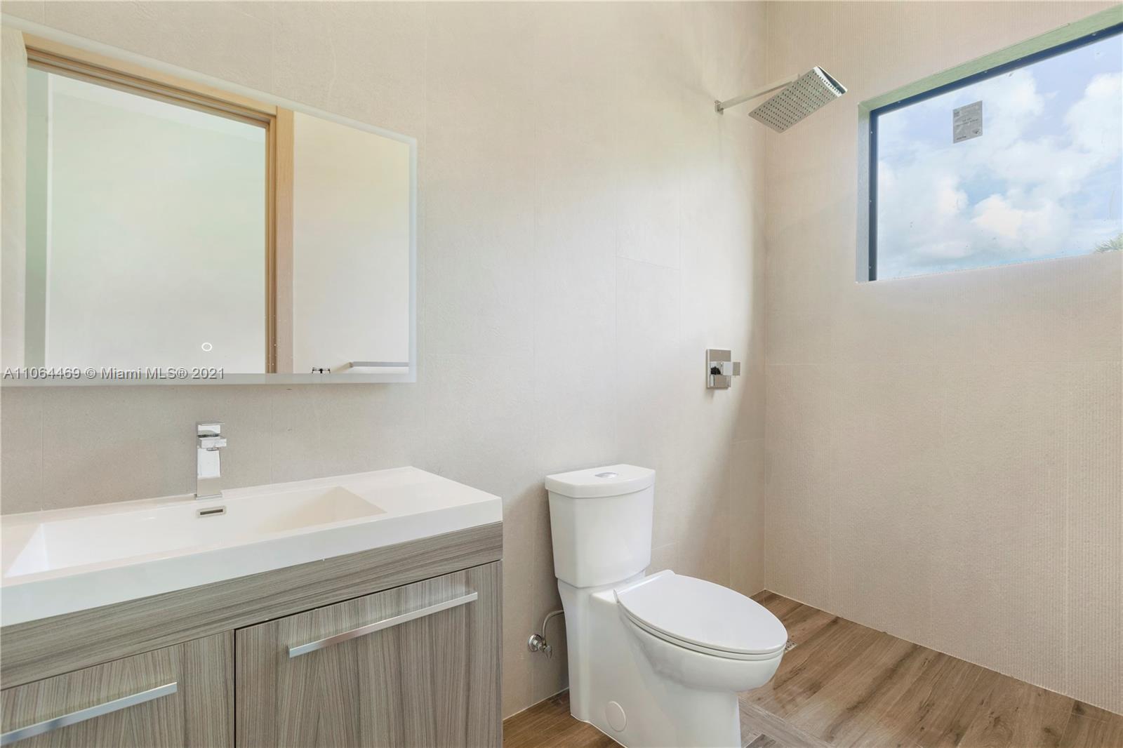 12701 Stirling Road Southwest Ranches, FL 33330 - Photo 29 of 38 a bathroom with a toilet a sink and a mirror