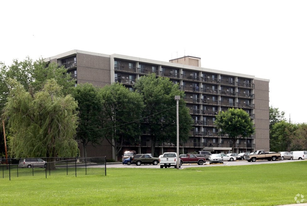 a front view of a building with lawn chairs and a big yard