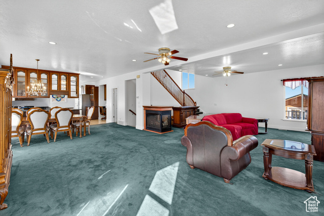 4768 East Hickman Canyon Road Stockton, UT 84071 - Photo 19 of 85 Living room with carpet, ceiling fan, a chandelier, recessed lighting, and stairs.