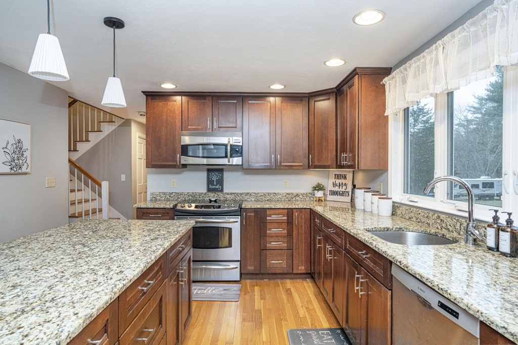 113 Pierce Street Rochester, MA 02770 - Photo 20 of 40 a kitchen with kitchen island granite countertop a sink a counter space appliances and cabinets