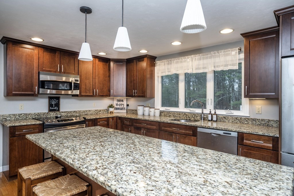 113 Pierce Street Rochester, MA 02770 - Photo 21 of 40 a kitchen with stainless steel appliances granite countertop wooden cabinets a stove a sink and a microwave