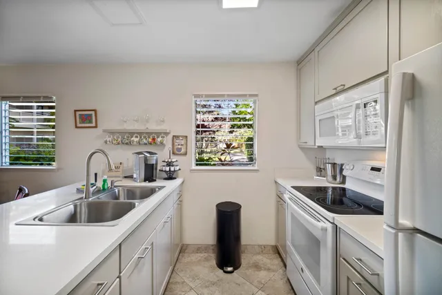 a kitchen with stainless steel appliances a sink a stove and cabinets
