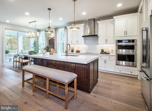 a kitchen with kitchen island granite countertop a table chairs sink and cabinets